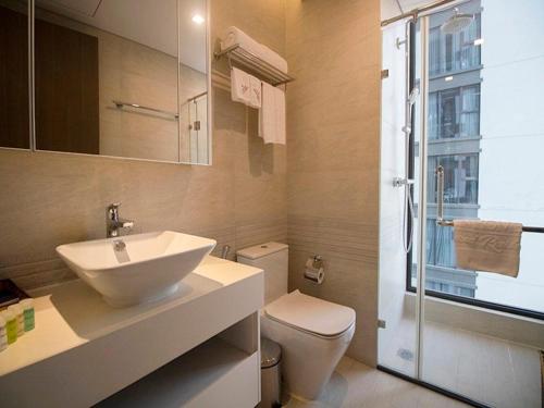 a bathroom with a sink and a toilet and a shower at Vinhomes Metropolis Hanoi Apartment Hotel in Hanoi