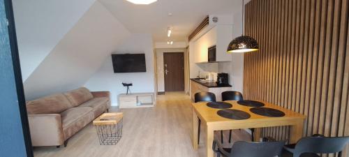 sala de estar con sofá y mesa de comedor en Apartament Triventi Karpacz en Karpacz