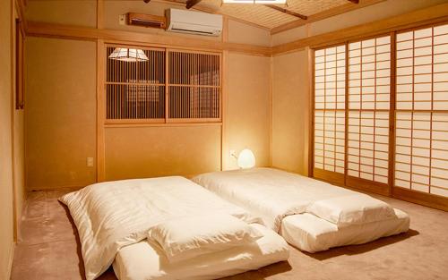 a bedroom with two white beds in a room at ZEN&BED Bogetsu-An in Koshu
