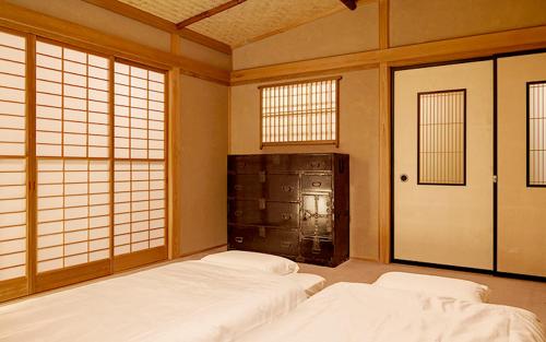 2 camas blancas en una habitación con ventanas en ZEN&BED Bogetsu-An, en Koshu