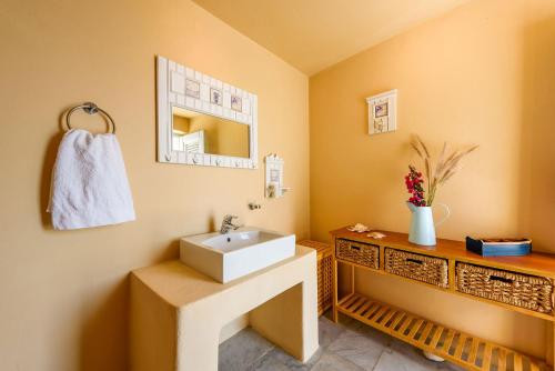La salle de bains est pourvue d'un lavabo et d'un miroir. dans l'établissement TLuxuryvilla, à Parikia