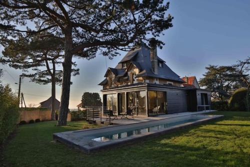 une maison avec une piscine dans la cour dans l'établissement Cigognes trouville, à Trouville-sur-Mer