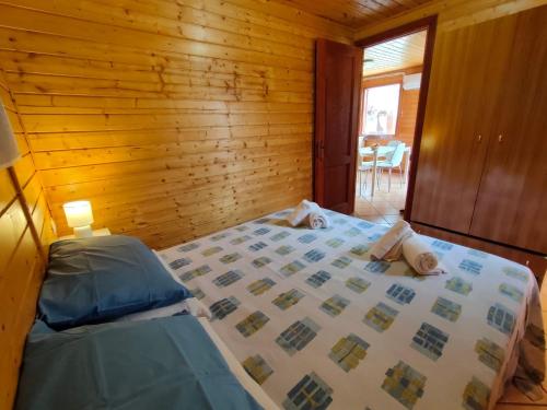 una camera con un letto e una parete in legno di Summer Paradise a Capitello (Ispani)