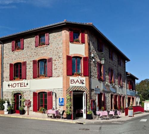 un gran edificio de ladrillo con persianas rojas y un bar en Relais des Monts du Lyonnais en Les Halles