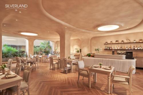 Silverland Sil Hotel في مدينة هوشي منه: مطعم بطاولات وكراسي وبار