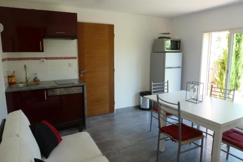 Il comprend une cuisine et une salle à manger avec une table et un réfrigérateur. dans l'établissement Dans le Var bas de villa plain- pied sur grand jardin avec entrée séparée, à Solliès-Toucas