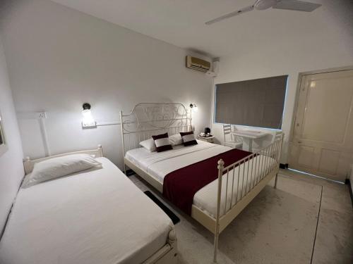um quarto com 2 camas e um quadro negro em Beverly Villa em Colombo