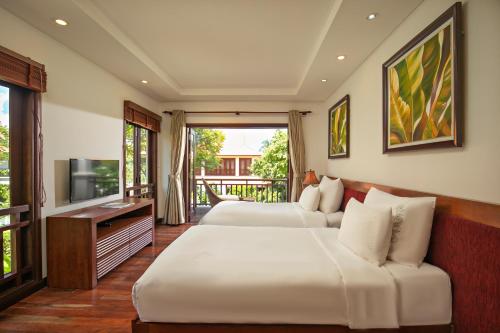 ダナンにあるDa Nang Beach Villa Resortのベッドルーム1室(ベッド2台、薄型テレビ付)