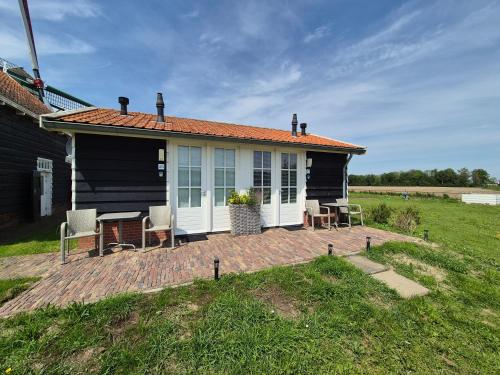 a house with a patio and a table and chairs at Landelijk slapen bij molen in Ovezande 4C in Ovezande