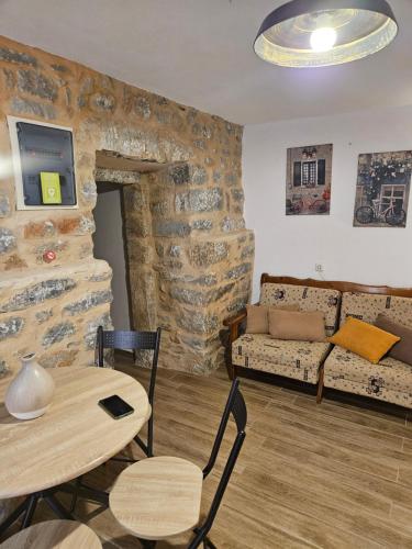 a living room with a table and a couch at Kamares Stone House 1 in Gerolimenas