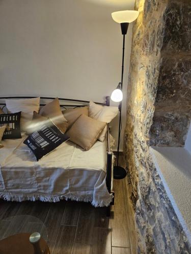 a bedroom with a bed with pillows and a lamp at Kamares Stone House 1 in Gerolimenas