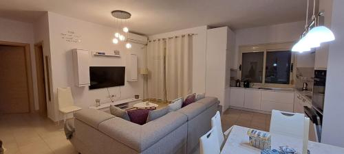 a living room with a couch and a kitchen at Seaside Apartment Plazhi vjeter in Vlorë