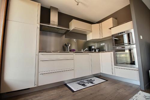 une cuisine avec des armoires blanches et un évier dans l'établissement ANNEMASSE - VICTORIA Centre ville, Grand T2 avec Terrasse, à Annemasse