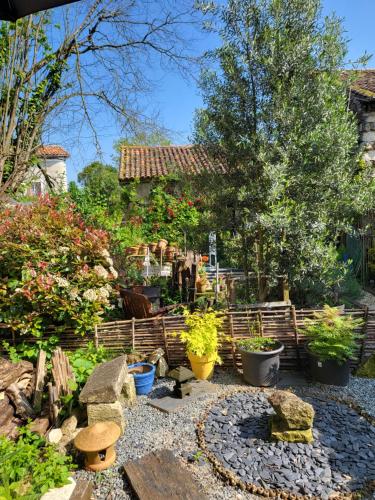 un jardin avec une bande de plantes et un bâtiment dans l'établissement Chambre d'Hote Woody, à Chef-Boutonne