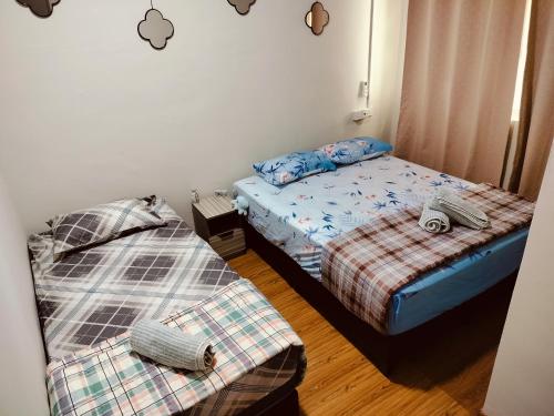 two beds in a small room with two bedsskirts at Idea Homestay 2 in Ipoh