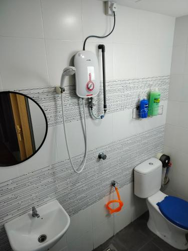 a bathroom with a sink and a mirror and a toilet at Idea Homestay 2 in Ipoh