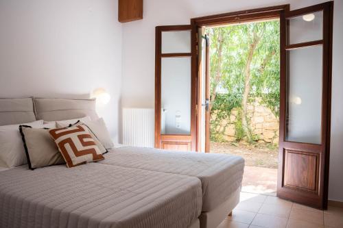 a bedroom with a bed and a sliding glass door at Aloe & Lotus Villas in Prinés