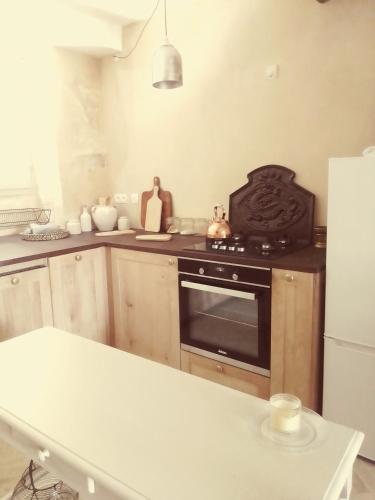 une cuisine avec une cuisinière et un réfrigérateur dans l'établissement Maison d'autrefois, à Chalabre