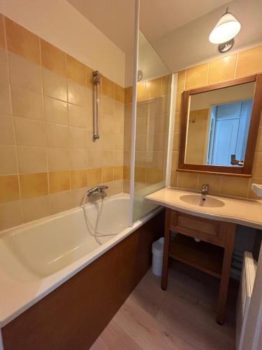 une salle de bain avec une baignoire, un lavabo et un miroir dans l'établissement Appt HAMEAU DU LAC, avec piscine, à Marciac