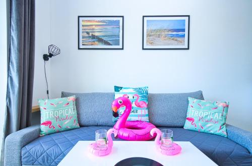 un flamingo rose assis sur un canapé avec une table dans l'établissement Pucki flaming, à Puck