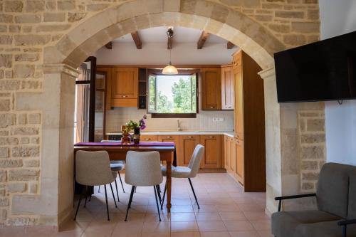 an archway in a kitchen with a table and chairs at Aloe & Lotus Villas in Prinés