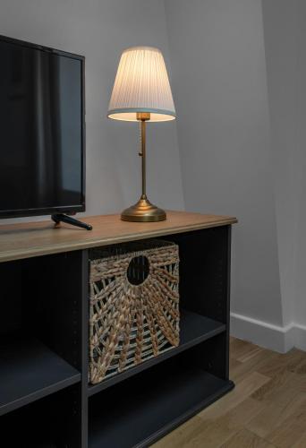 a table with a lamp and a television on top at Le Grand Wilson - Appartement design - Hyper centre in Vichy
