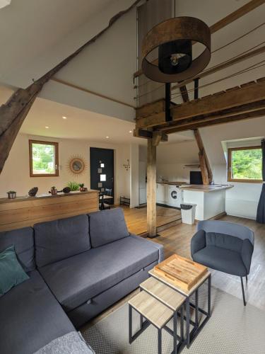 un salon avec un canapé bleu et une table dans l'établissement Appartement au calme entre Terre et Mer. Proche Honfleur (5min) Deauville (15min), à Barneville-la-Bertrand