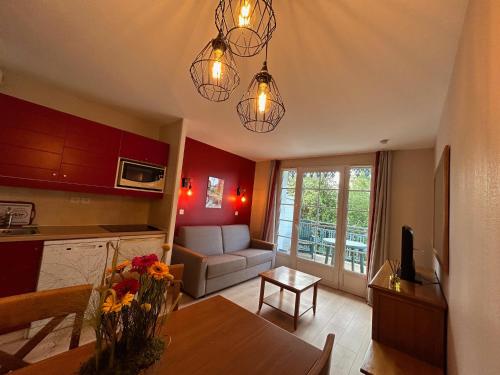 une cuisine et un salon avec un canapé et une table dans l'établissement Appt HAMEAU DU LAC (apt 142) avec piscine et vue sur le lac, à Marciac