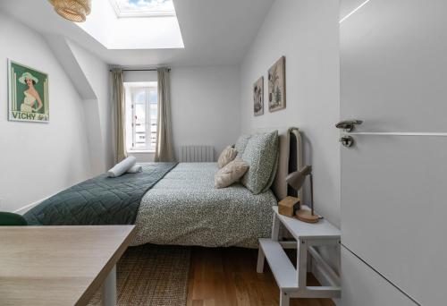 a bedroom with a bed and a desk and a window at Le Grand Wilson - Appartement design - Hyper centre in Vichy