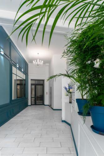 a hallway with potted plants in a building at Le Grand Wilson - Appartement design - Hyper centre in Vichy
