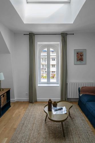 a living room with a couch and a table at Le Grand Wilson - Appartement design - Hyper centre in Vichy