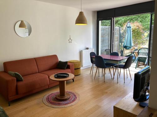 un salon avec un canapé et une table dans l'établissement Loft 3 pieces sur jardin - 15 minutes de Paris avec parking, à Bagneux