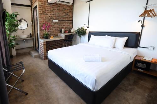 a bedroom with a large bed and a brick wall at Suite 18 Boutique Hotel in Kuala Terengganu