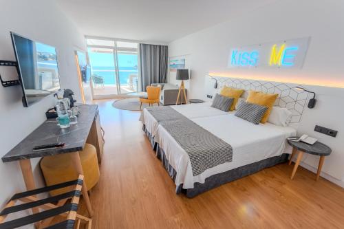 a bedroom with a king sized bed and a living room at Flamboyan Caribe Hotel & Spa in Magaluf