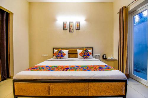 a bedroom with a bed and a large window at FabHotel G-5 Villa in Ludhiana