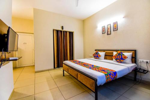 1 dormitorio con 1 cama y TV de pantalla plana en FabHotel G-5 Villa en Ludhiana