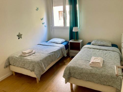 une chambre avec deux lits et une fenêtre dans l'établissement Loft 3 pieces sur jardin - 15 minutes de Paris avec parking, à Bagneux