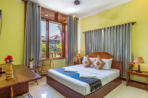sypialnia z łóżkiem, biurkiem i oknem w obiekcie Side Walk Hotel w Siem Reap