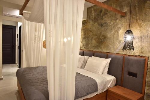 a bedroom with a bed with a white canopy at Rafael Hotel-Adults Only in Lindos