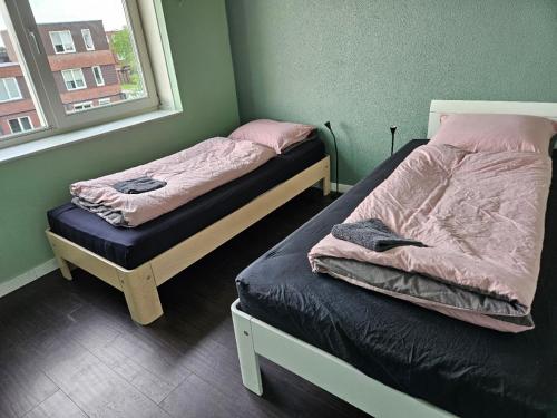 2 aparte bedden in een kamer met een raam bij Residence Sanne in Breda