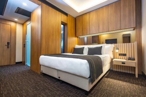 a bedroom with a large bed with wooden walls at FT Lotus Thermal Hotel&SPA Trademark Collection by Wyndham in Menemen