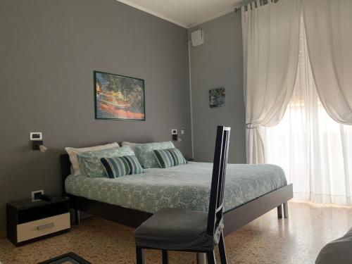 a bedroom with a bed and a chair and a window at B&B Residence Armonia Sulmona in Sulmona