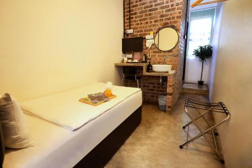 ein Schlafzimmer mit einem Bett, einem Spiegel und einem Stuhl in der Unterkunft Suite 18 Boutique Hotel in Kuala Terengganu