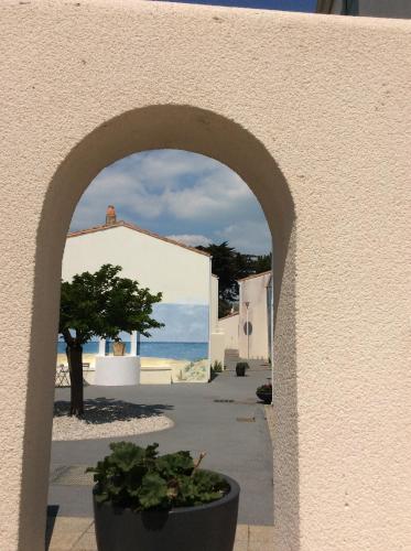 une arche avec une plante en pot dans une rue dans l'établissement Agréable logt à La Flotte en Ré avec piscine, à La Flotte