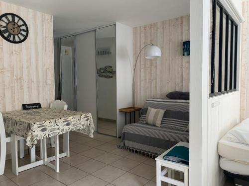Cette petite chambre comprend une table et un lit. dans l'établissement Agréable logt à La Flotte en Ré avec piscine, à La Flotte
