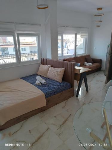 a bedroom with a bed and a table and a couch at Zara's Boutique near Venizelos metro station in Thessaloniki