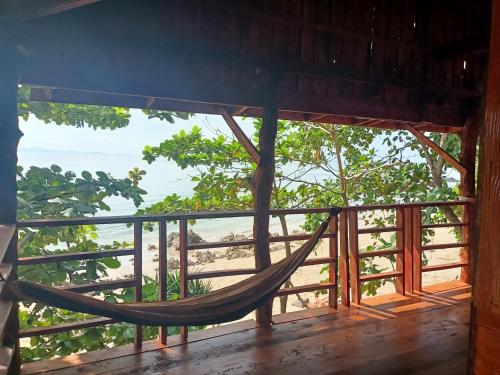 ジュム島にあるジャングル ヒル ビーチ バンガローのビーチを望む客室内のハンモック