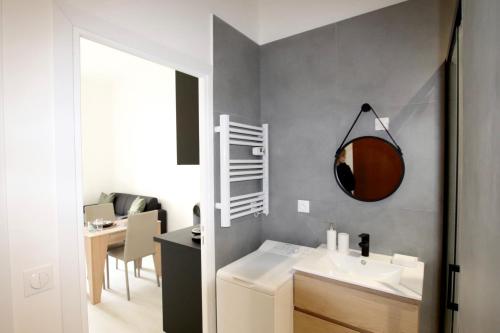 une salle de bain avec un lavabo et un miroir au mur dans l'établissement La Villa Riquet Menton, à Menton