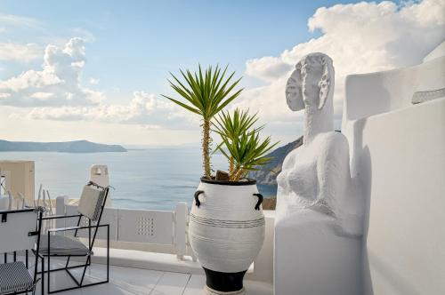 a terrace with a plant in a large white vase at Trieris Villa & Suites in Fira