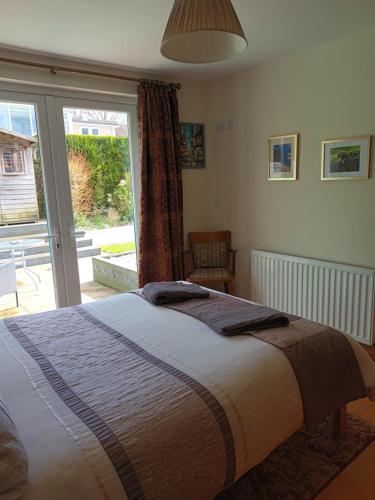 une chambre avec un lit et une porte coulissante en verre dans l'établissement Fell View House, à Kendal